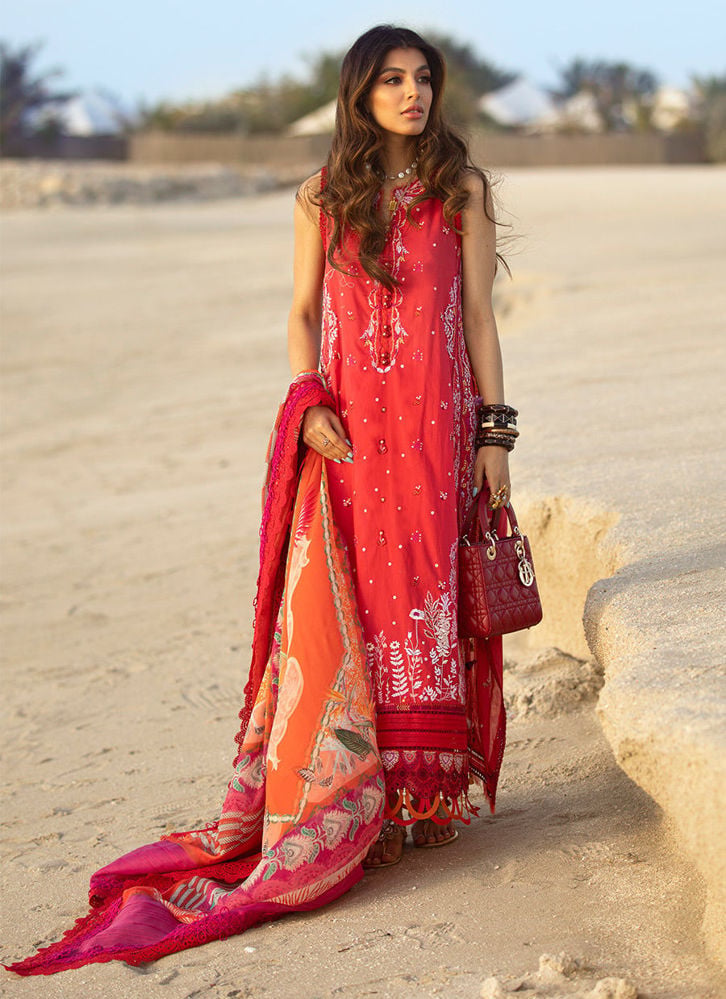 Woman in a red traditional outfit with a matching dupatta on a sandy background