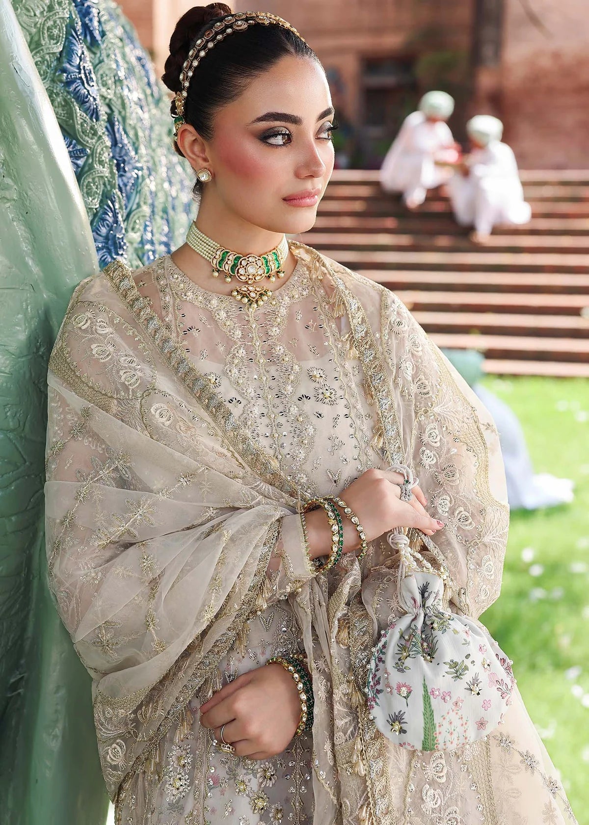 Woman in traditional embroidered outfit with a garden background