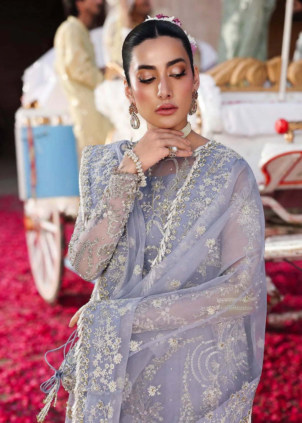 Woman in a light blue embroidered outfit with a blurred background