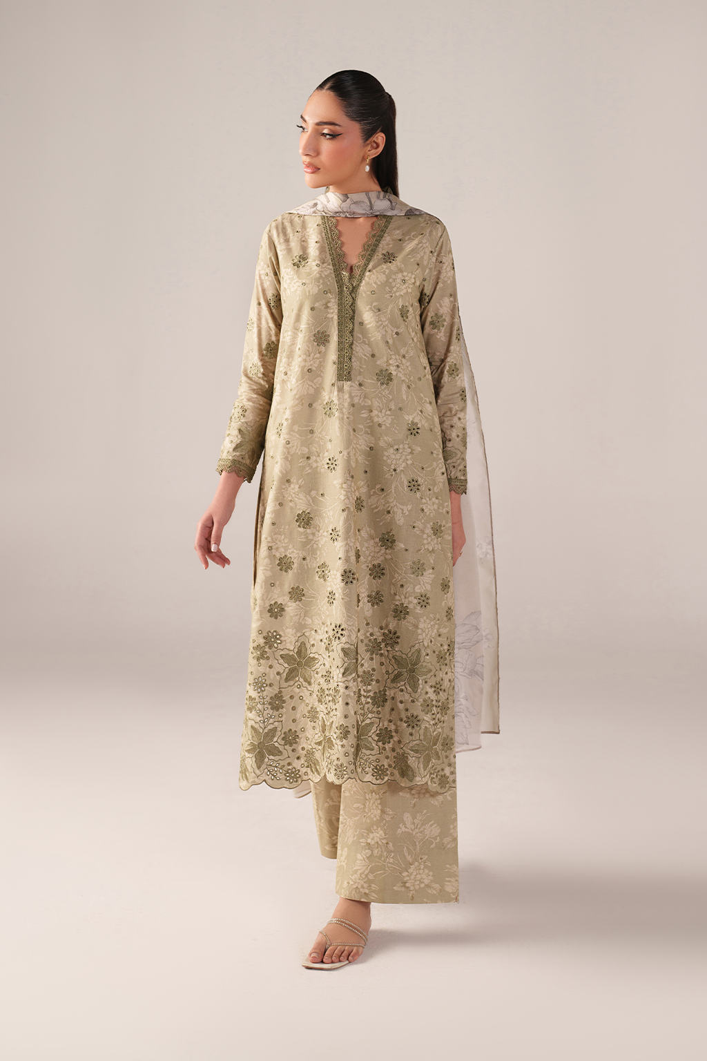 Woman wearing a beige floral kurta with a plain white dupatta on a light gray background