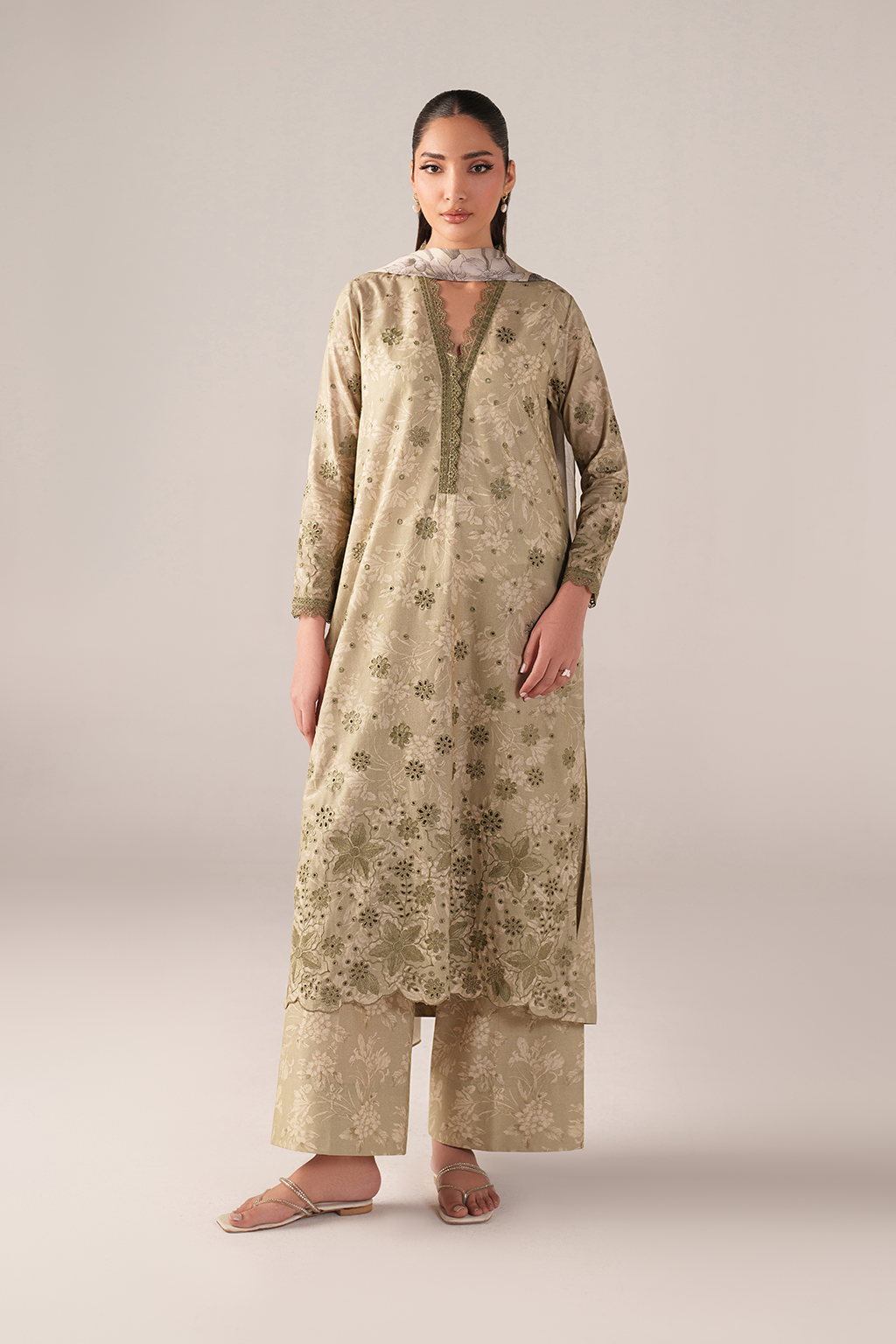 Woman wearing a beige floral dress with a plain background
