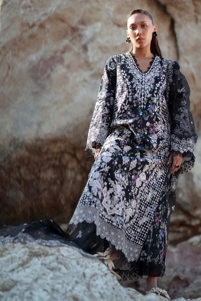 Woman in a floral dress standing against a textured stone wall.