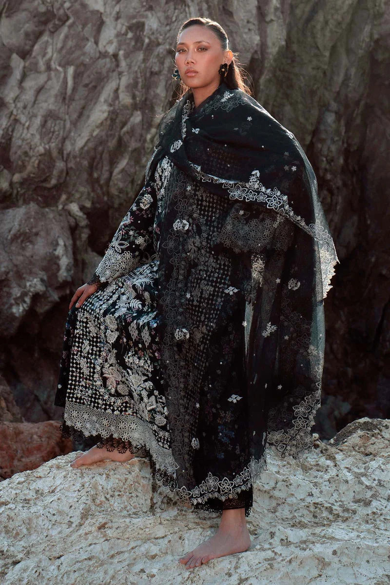 Woman in a black and white patterned outfit standing on rocky terrain.