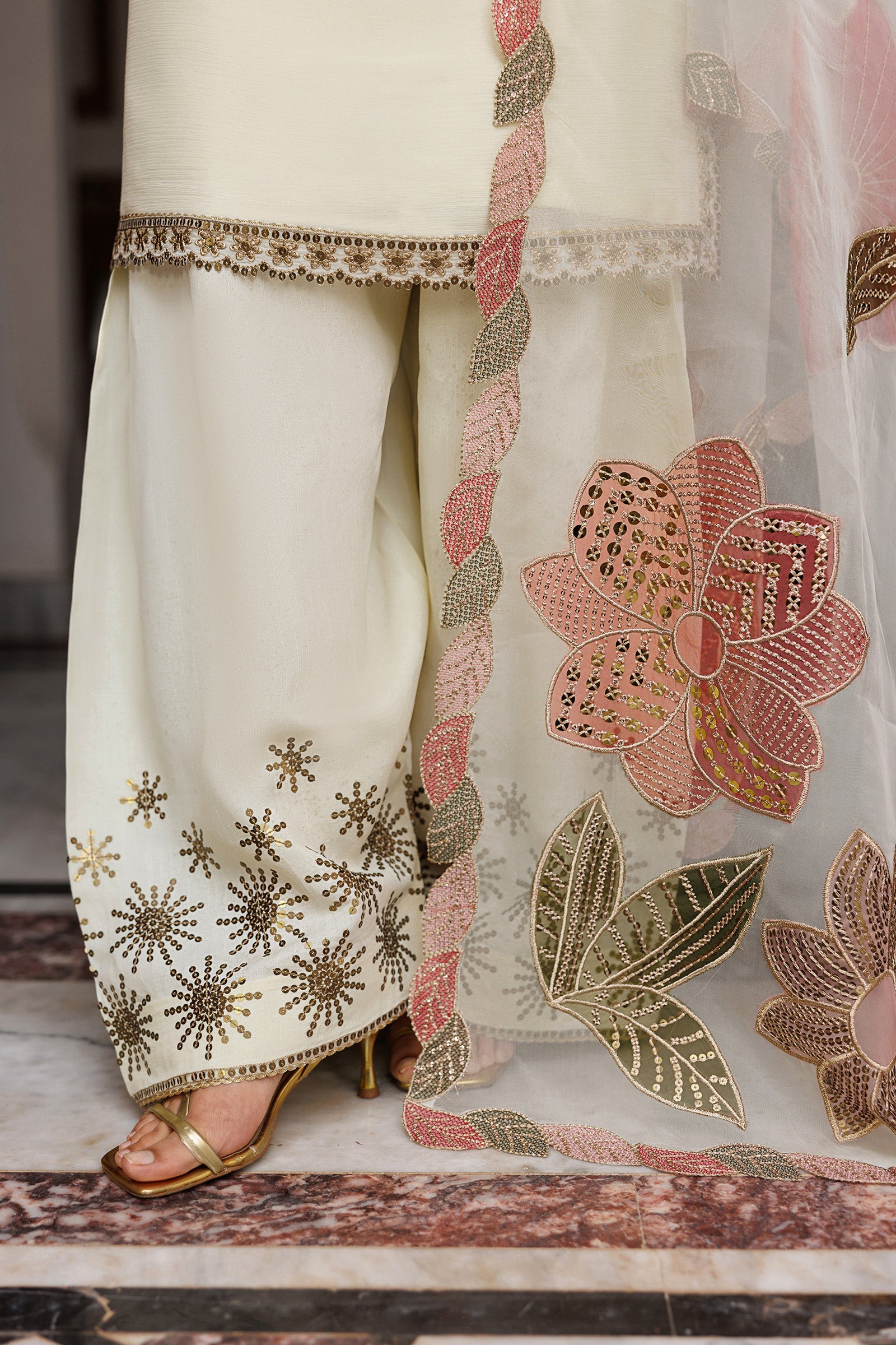 Traditional outfit with floral embroidery on a marble floor