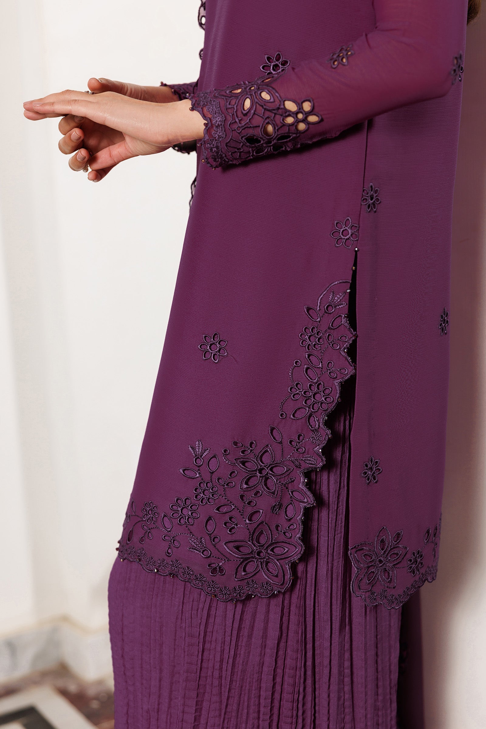 Purple dress with intricate lace detailing on a plain background