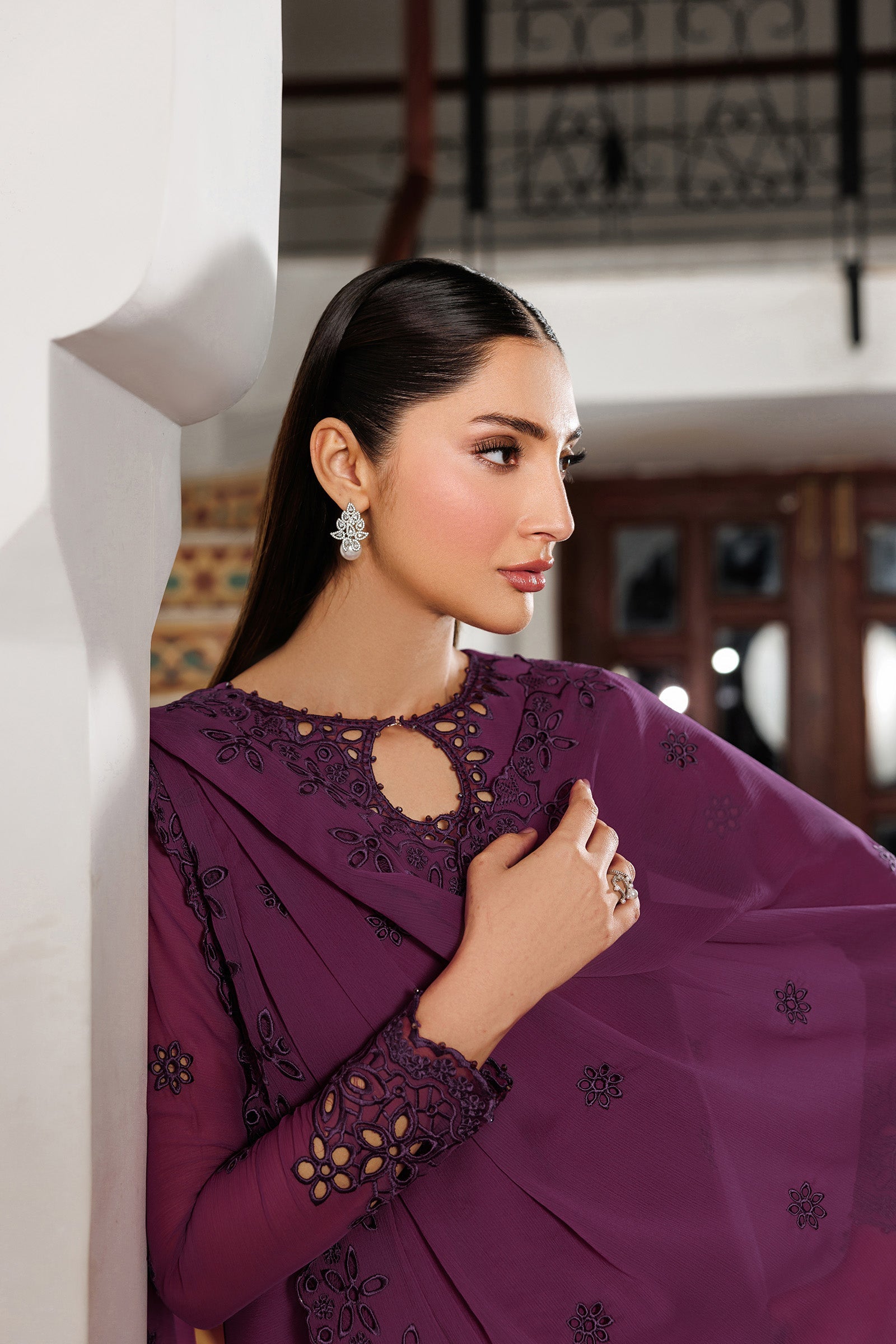 Woman wearing a purple embroidered outfit in an indoor setting