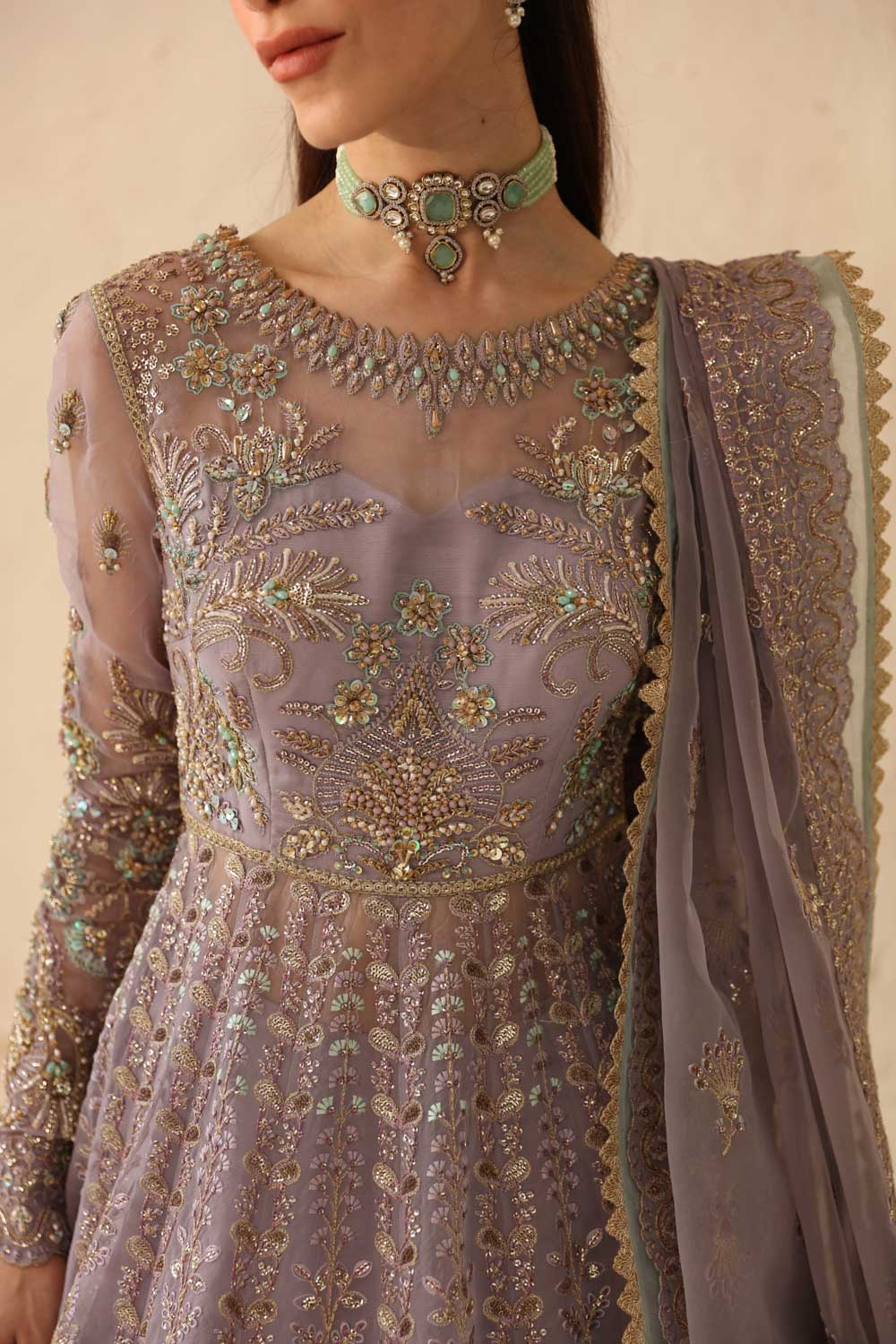 Elegant outfit with intricate embroidery and a matching shawl, worn by a model.
