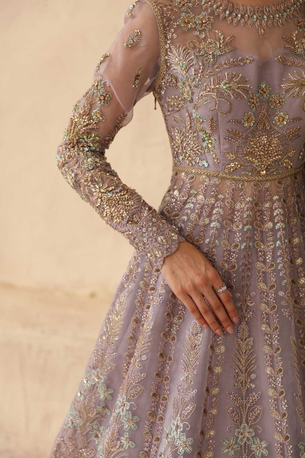 Elegant dress with intricate gold embroidery on a beige background