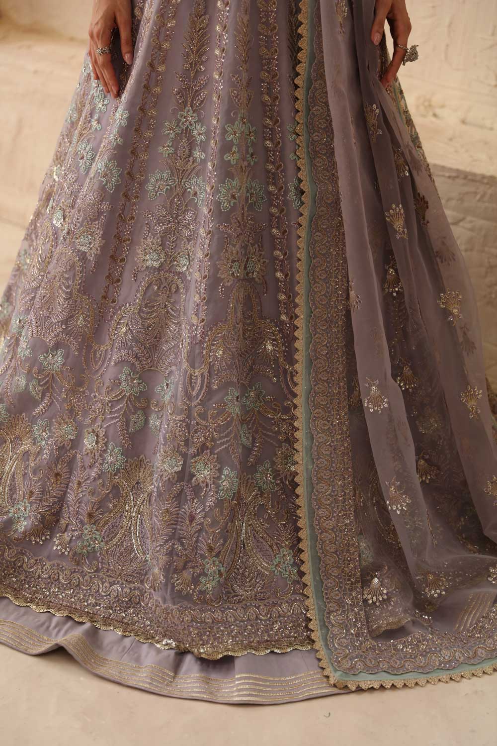 Close-up of a embroidered traditional outfit with intricate patterns on a neutral background