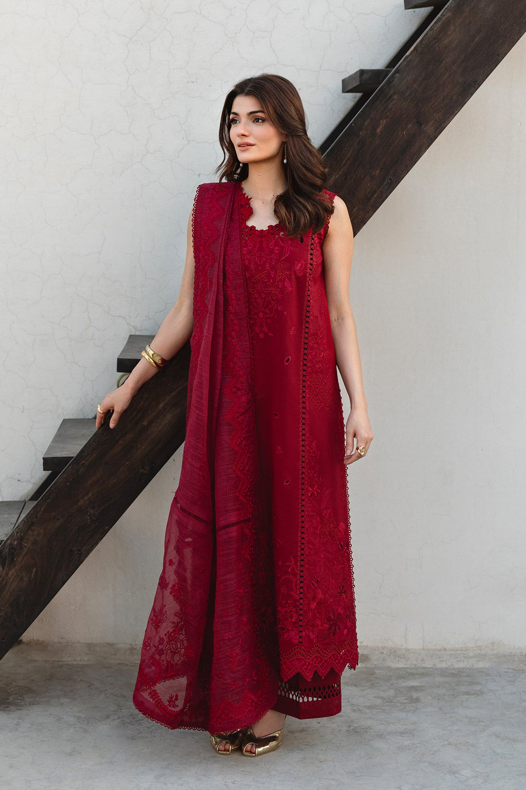 Woman in a red traditional outfit standing on a staircase.