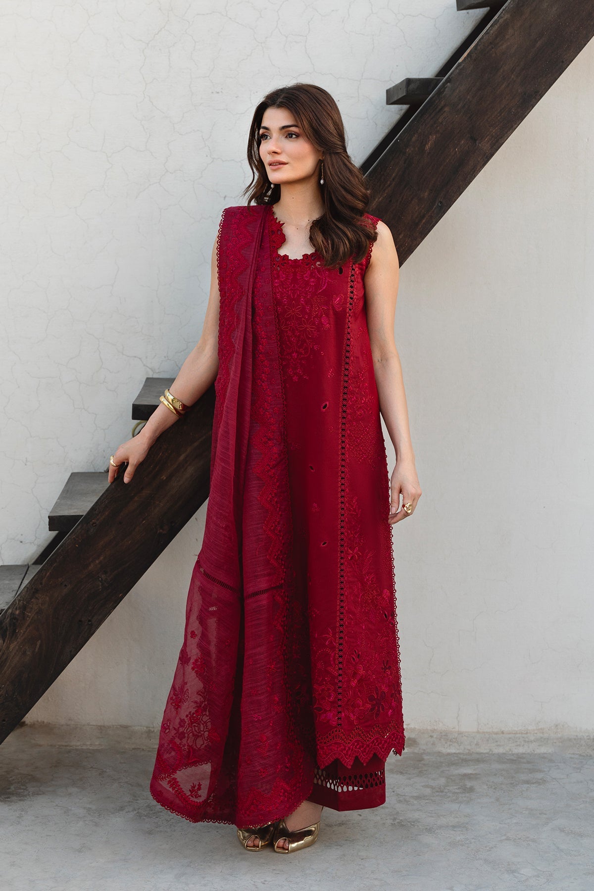Woman in a red traditional outfit standing on a staircase.