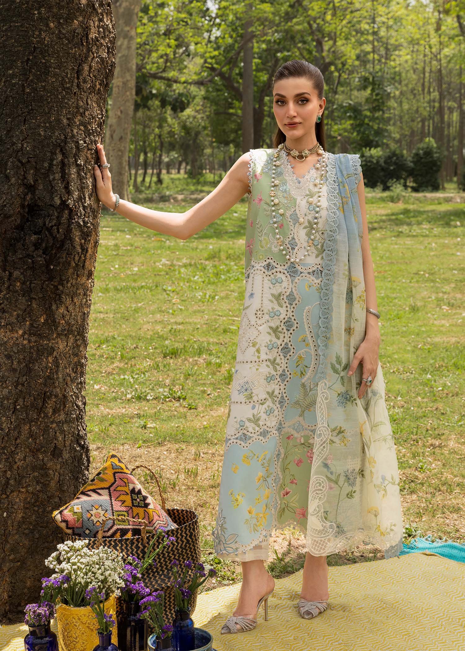 Woman in a floral dress standing outdoors near a tree