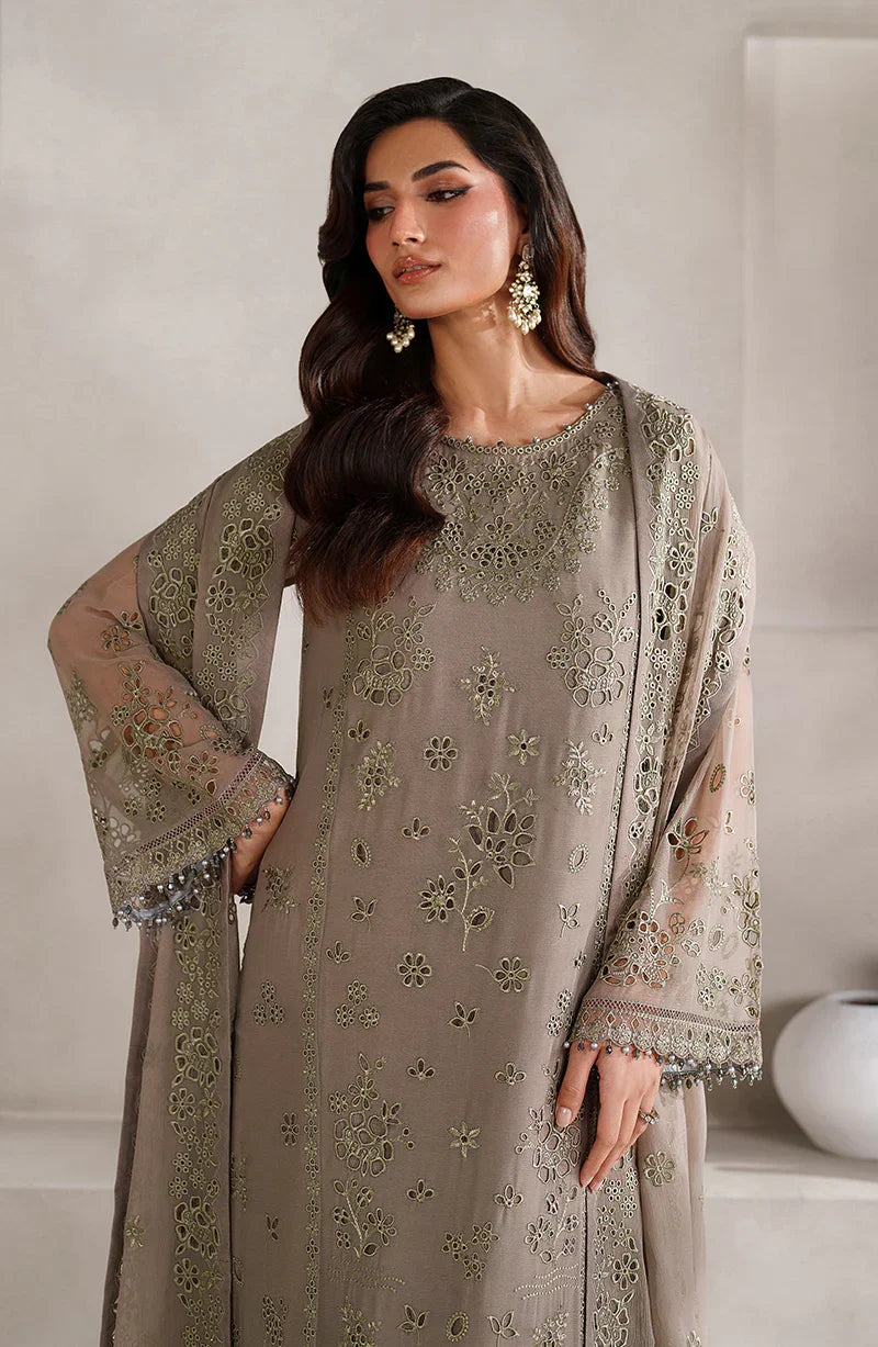 Woman wearing a beige embroidered outfit with a matching dupatta against a white background