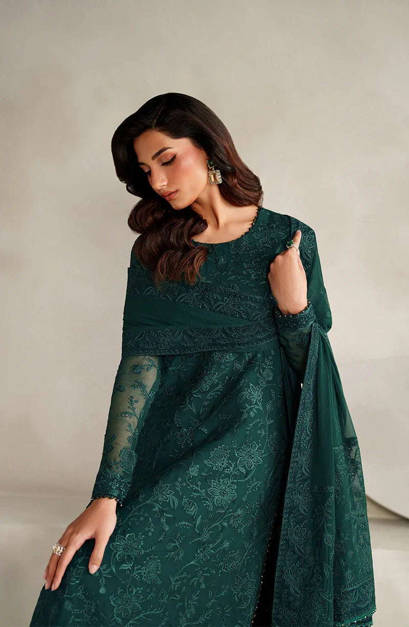 Woman wearing a green lace dress against a plain background