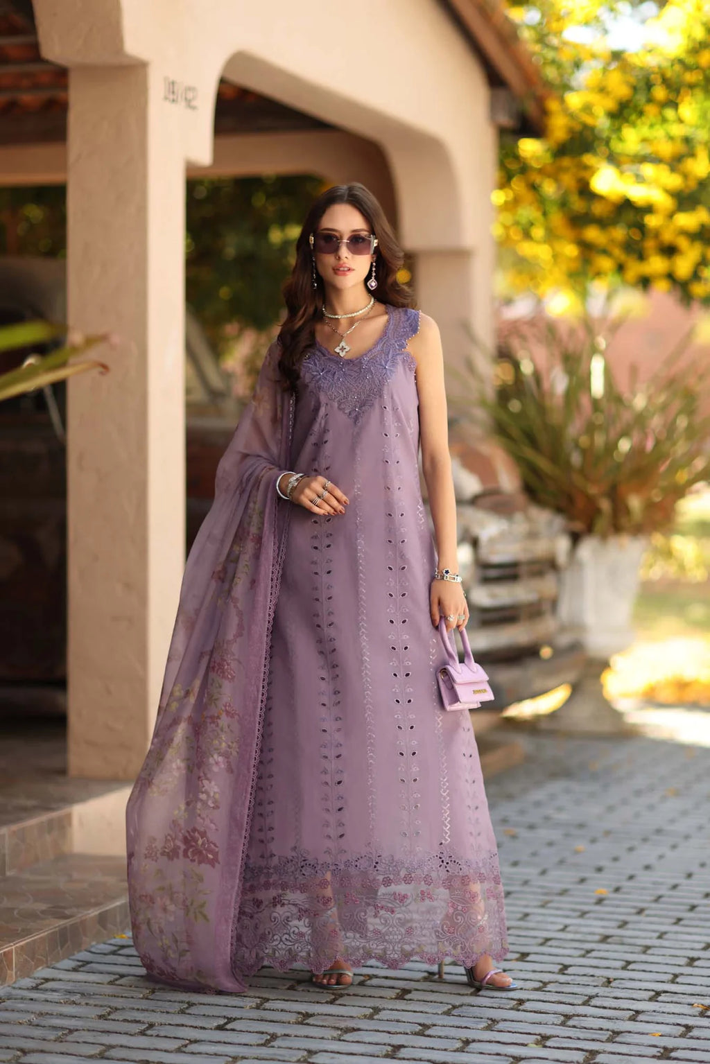 Woman in a long purple dress standing outdoors with a blurred background
