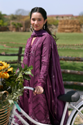 Woman in a purple traditional outfit with a bicycle and flowers outdoors