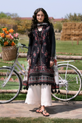 Woman in traditional attire standing next to a bicycle with flowers in a basket, outdoors.