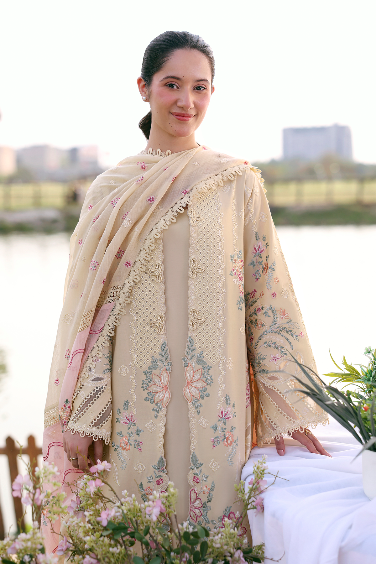 Woman wearing a beige embroidered saree with a blurred background