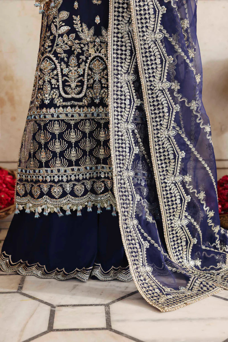 Navy blue embroidered traditional outfit with gold detailing on a light background