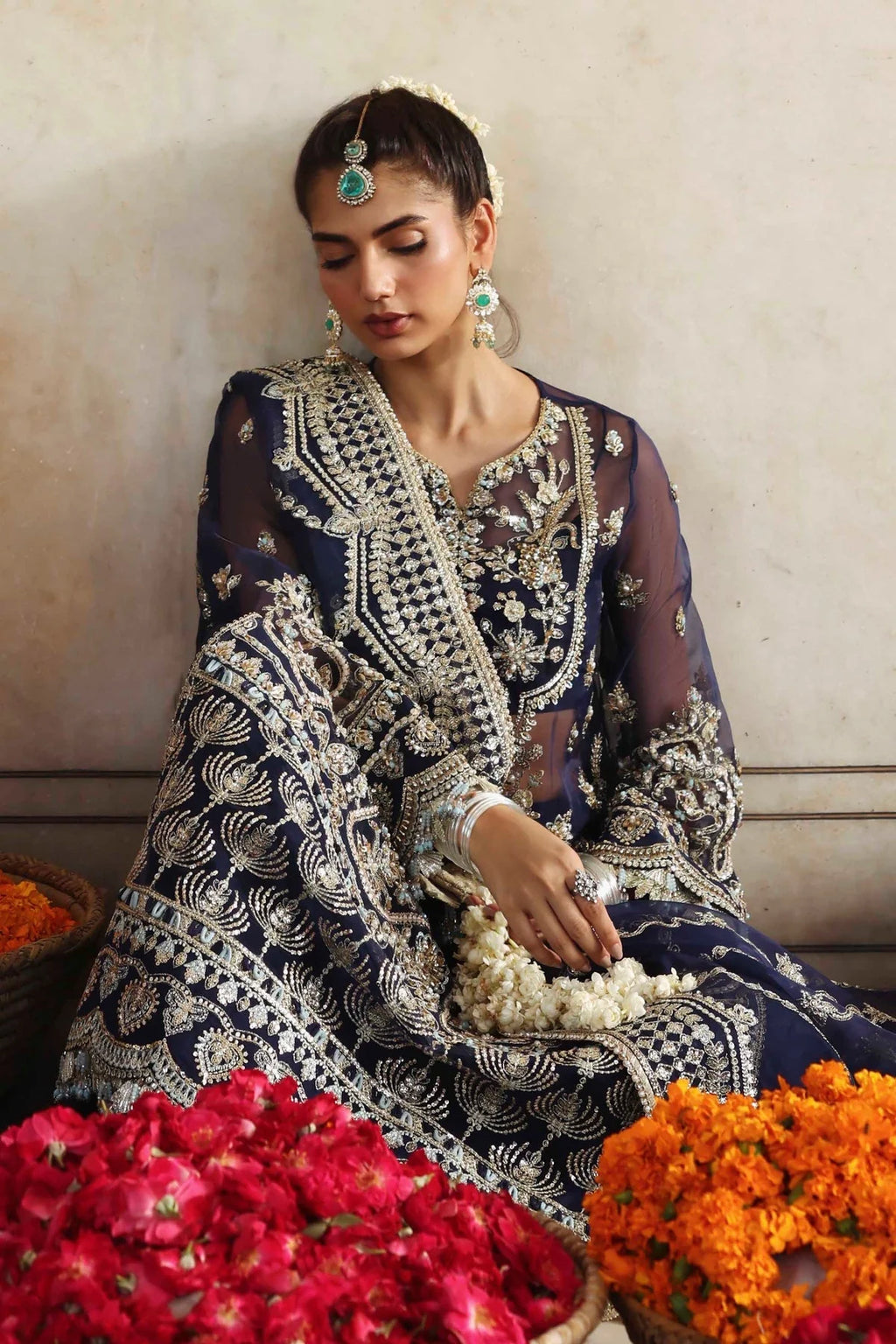 Woman in traditional embroidered outfit with flowers and a neutral background