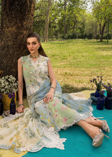 Woman in a floral dress sitting on a blanket outdoors with trees and grass in the background