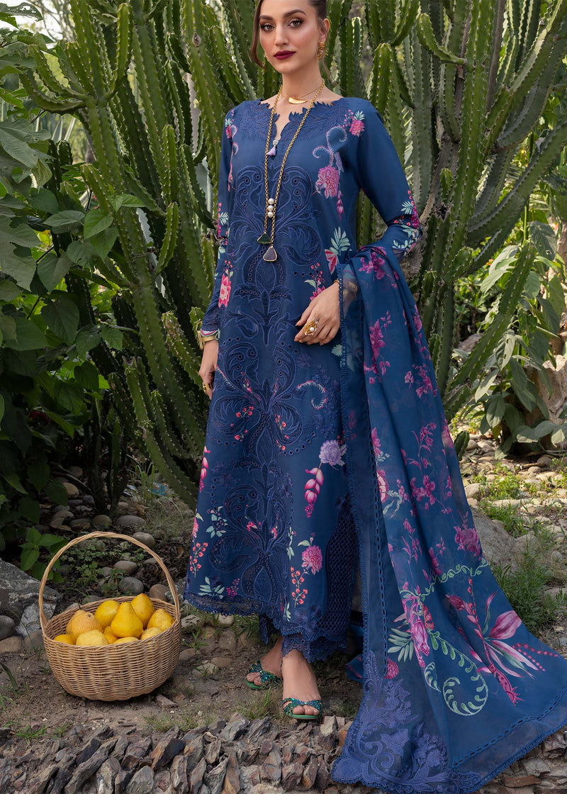 Woman in a blue floral dress standing in front of cacti with a basket of lemons.