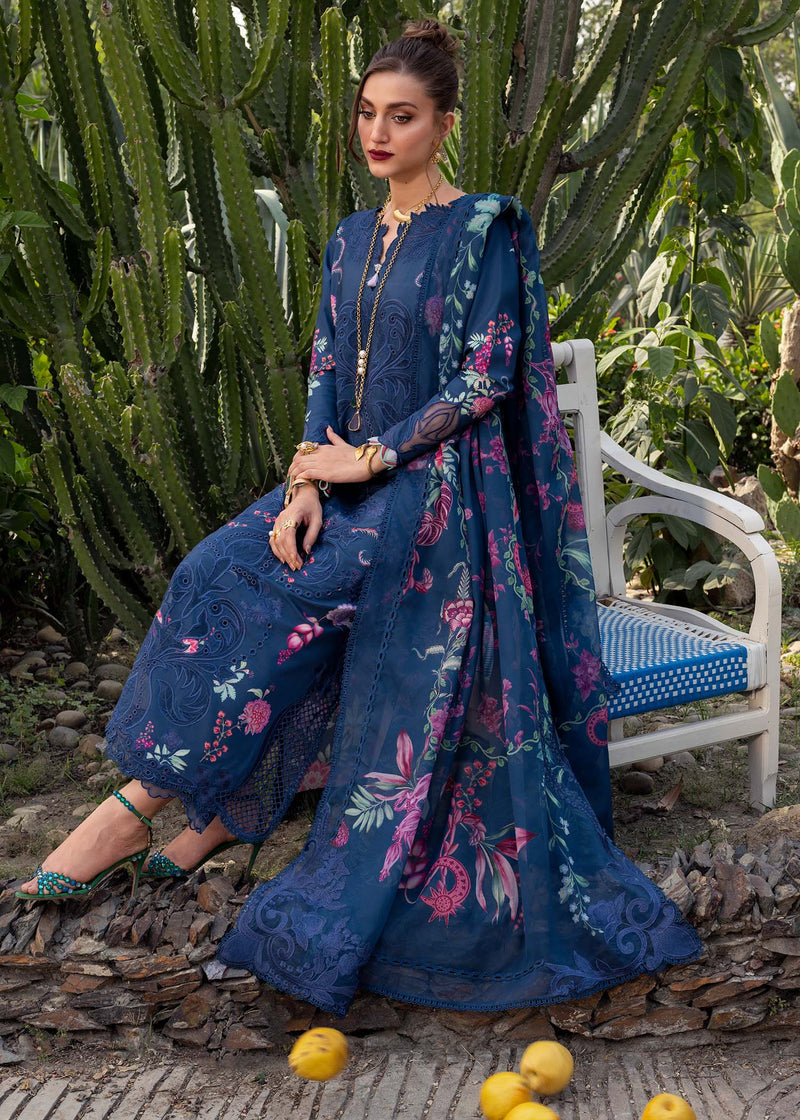 Woman in a blue embroidered outfit sitting on a white chair with cacti in the background