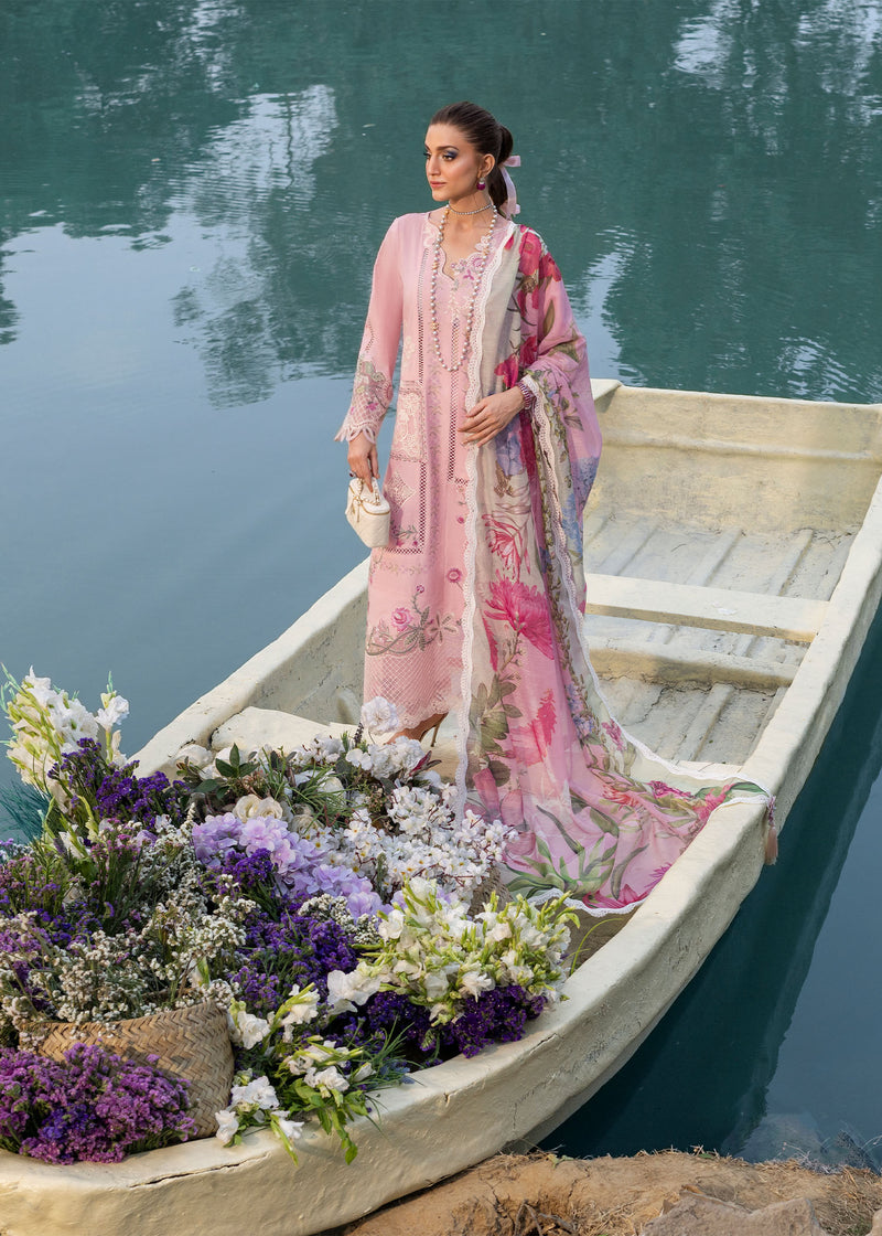 Woman in a pink floral dress on a boat with flowers, surrounded by water.