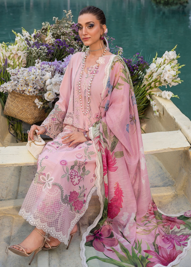 Woman in a pink embroidered outfit sitting by a pool with flowers around her