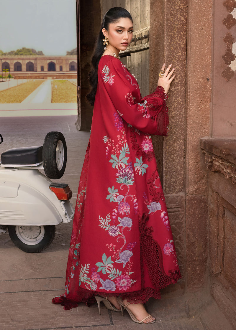 Woman in a red floral dress standing next to a vintage scooter in an outdoor setting.