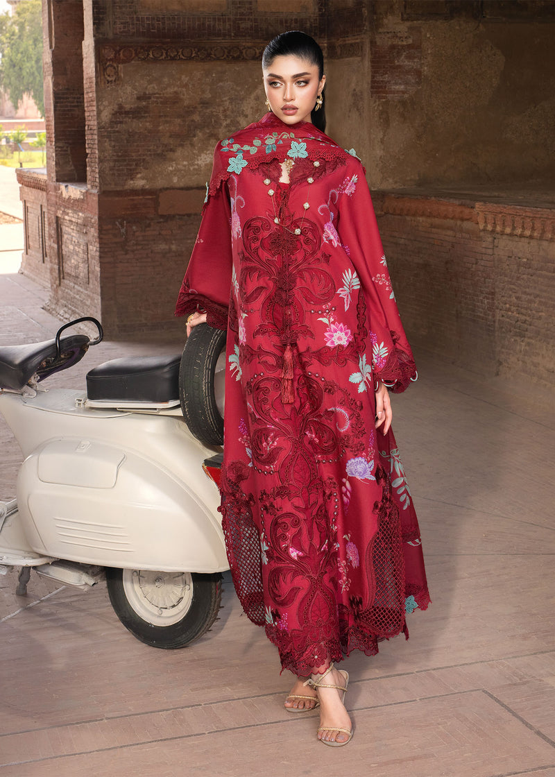 Woman in a red embroidered outfit standing next to a scooter in an outdoor setting.