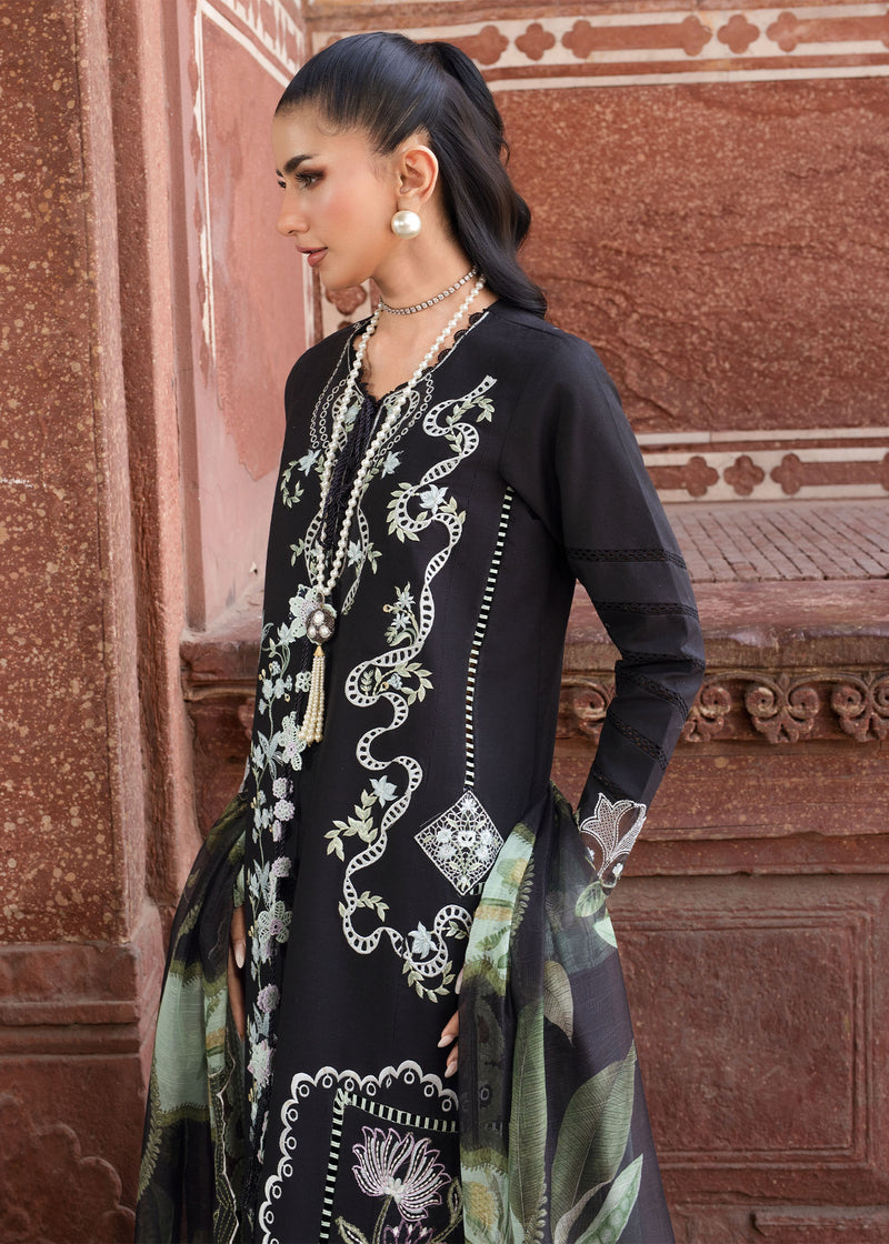 Woman wearing a black embroidered outfit with a floral pattern in an ornate setting