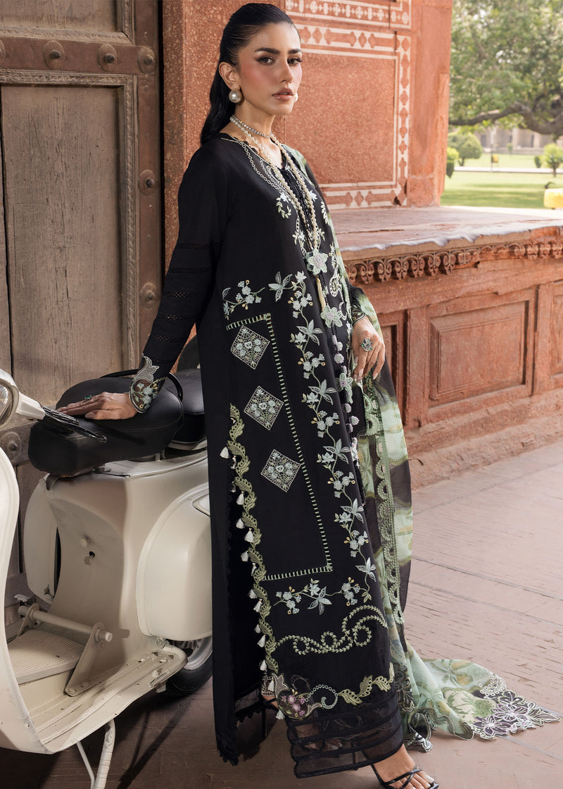 Woman in black embroidered outfit standing next to a scooter with a traditional building in the background