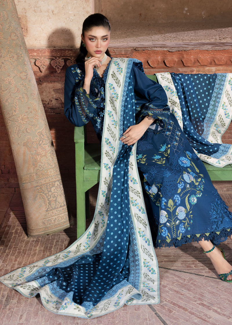 Woman in a blue embroidered traditional outfit sitting on a bench.