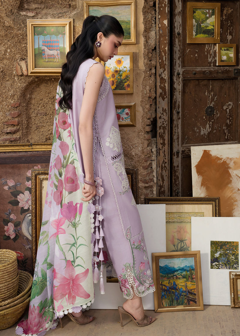 Woman in a floral dress standing in an art gallery with framed paintings on the wall.
