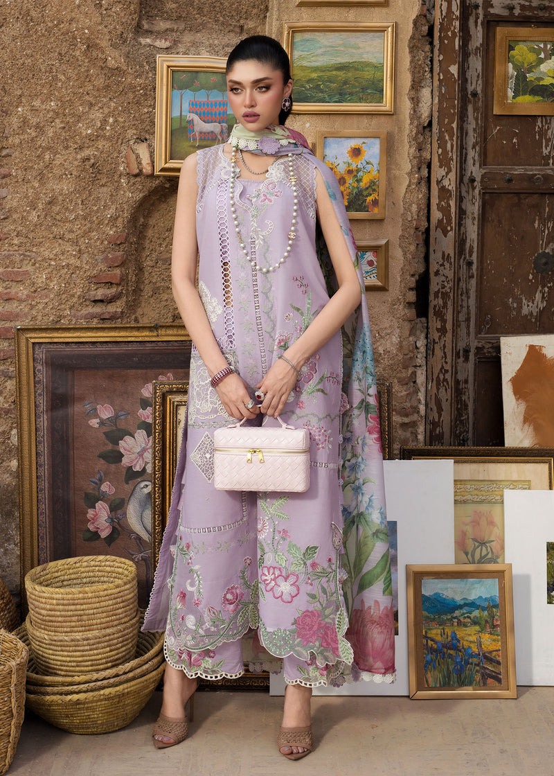 Woman in a floral dress holding a pink handbag in a room with framed pictures on the wall.