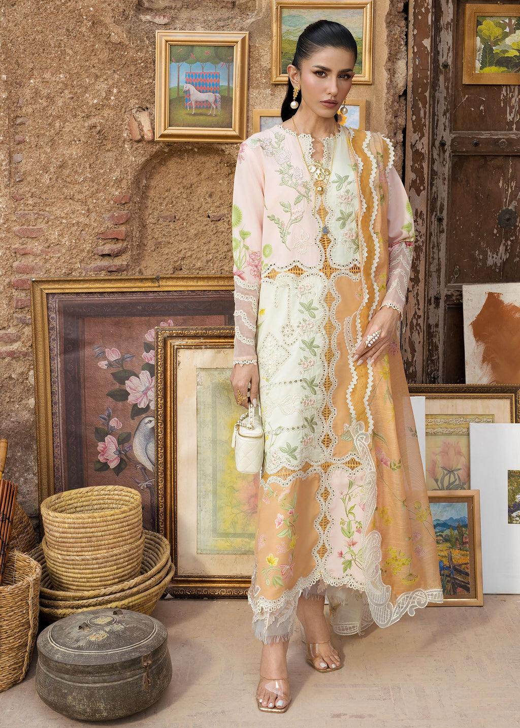 Woman in a floral dress standing in a room with rustic decor and framed pictures.