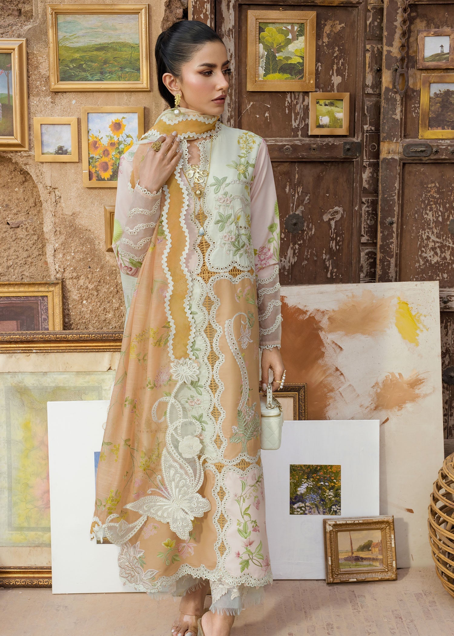 Woman in a floral dress standing in an art gallery with paintings on the wall.