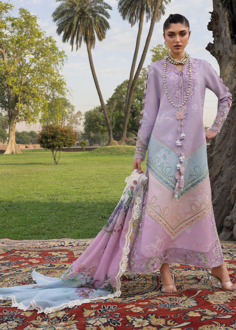Woman in a traditional outfit standing outdoors with trees and grass in the background