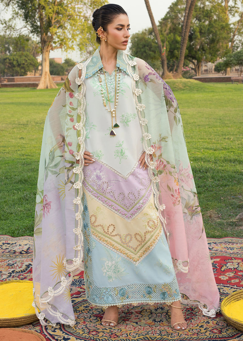 Woman in traditional embroidered outfit with a floral shawl outdoors.