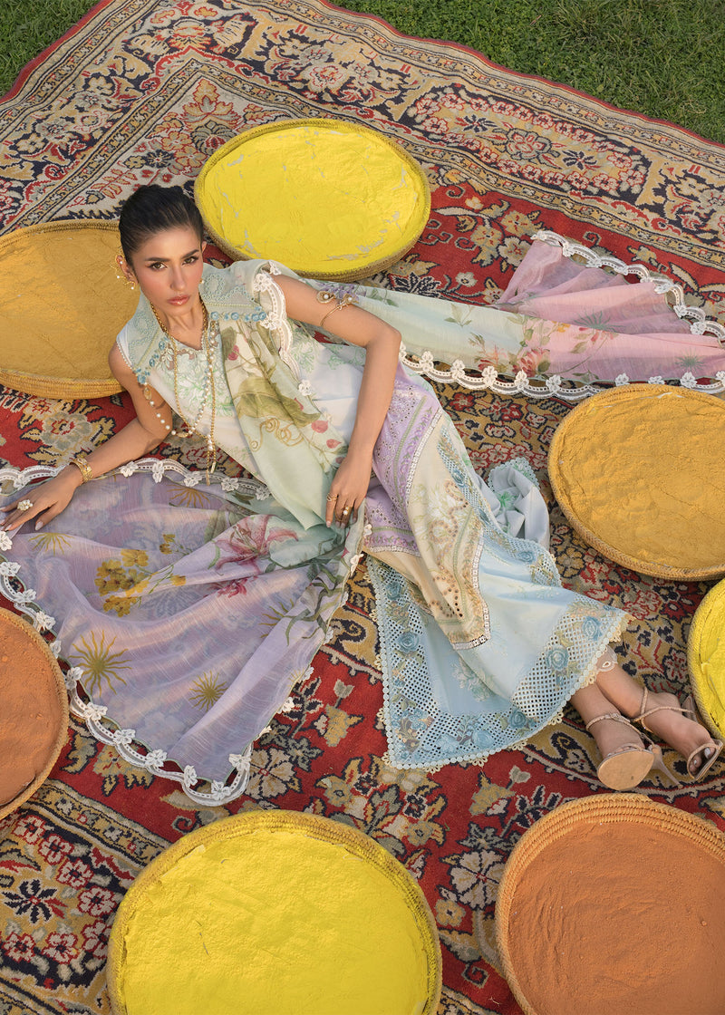 Woman in a floral dress lying on a patterned rug with yellow and orange cushions.