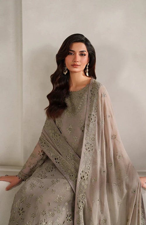 Woman wearing a gray embroidered outfit with a matching dupatta against a neutral background