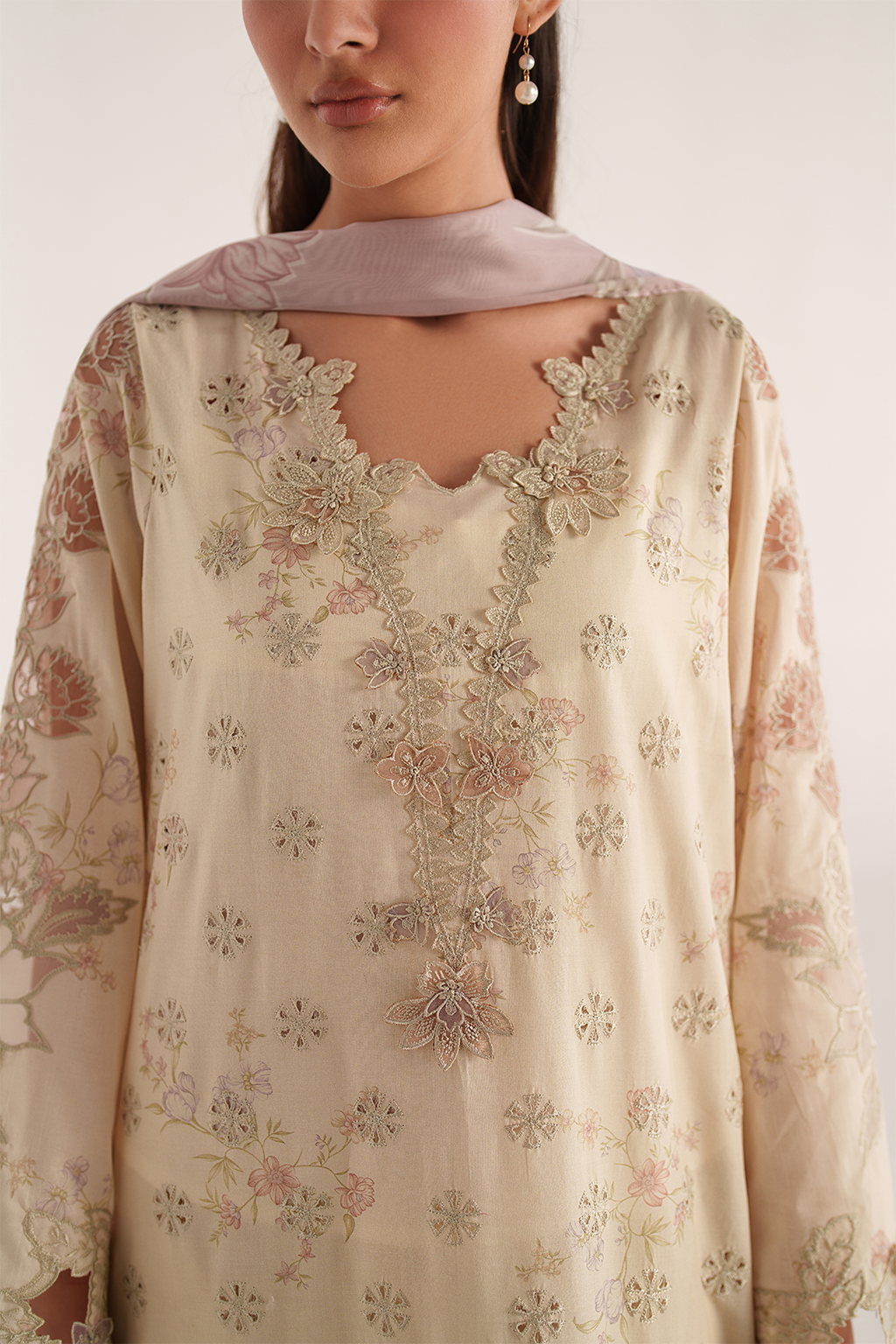 Beige embroidered traditional outfit with a plain background
