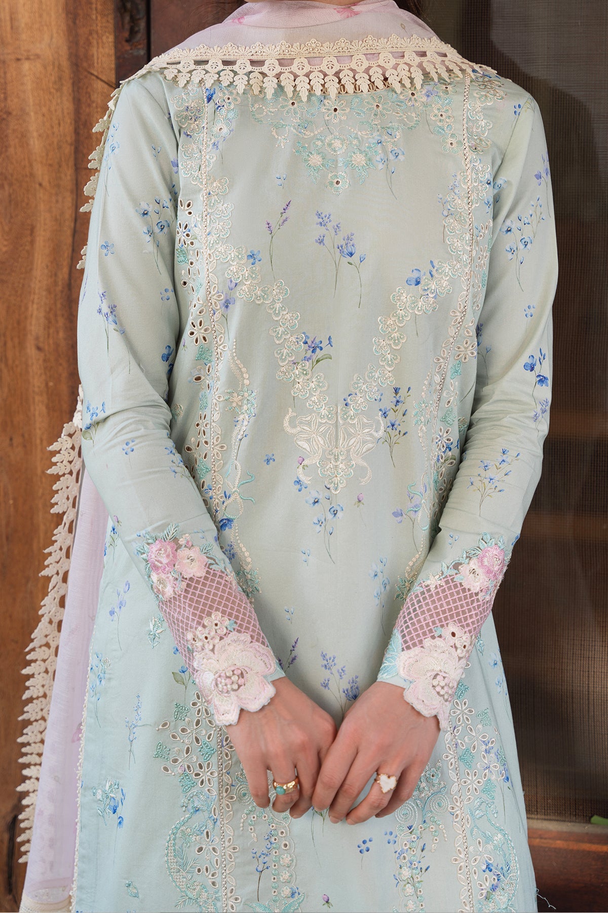 Light blue embroidered traditional outfit with floral patterns and lace details.