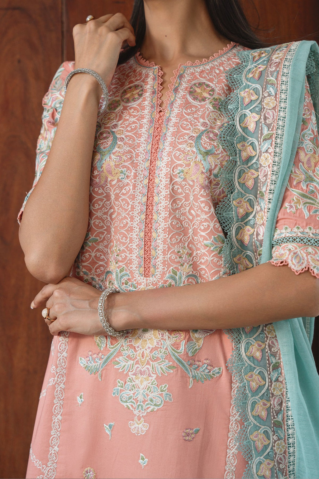 Woman wearing a traditional embroidered outfit with a focus on the upper body.