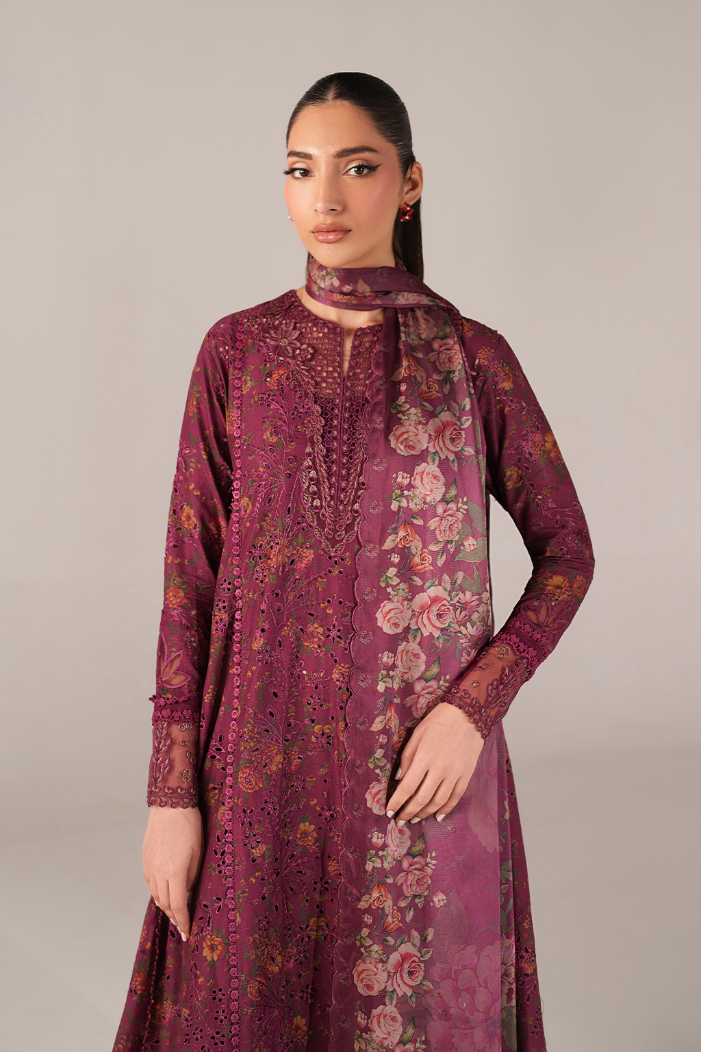 Woman wearing a purple floral embroidered outfit against a plain background