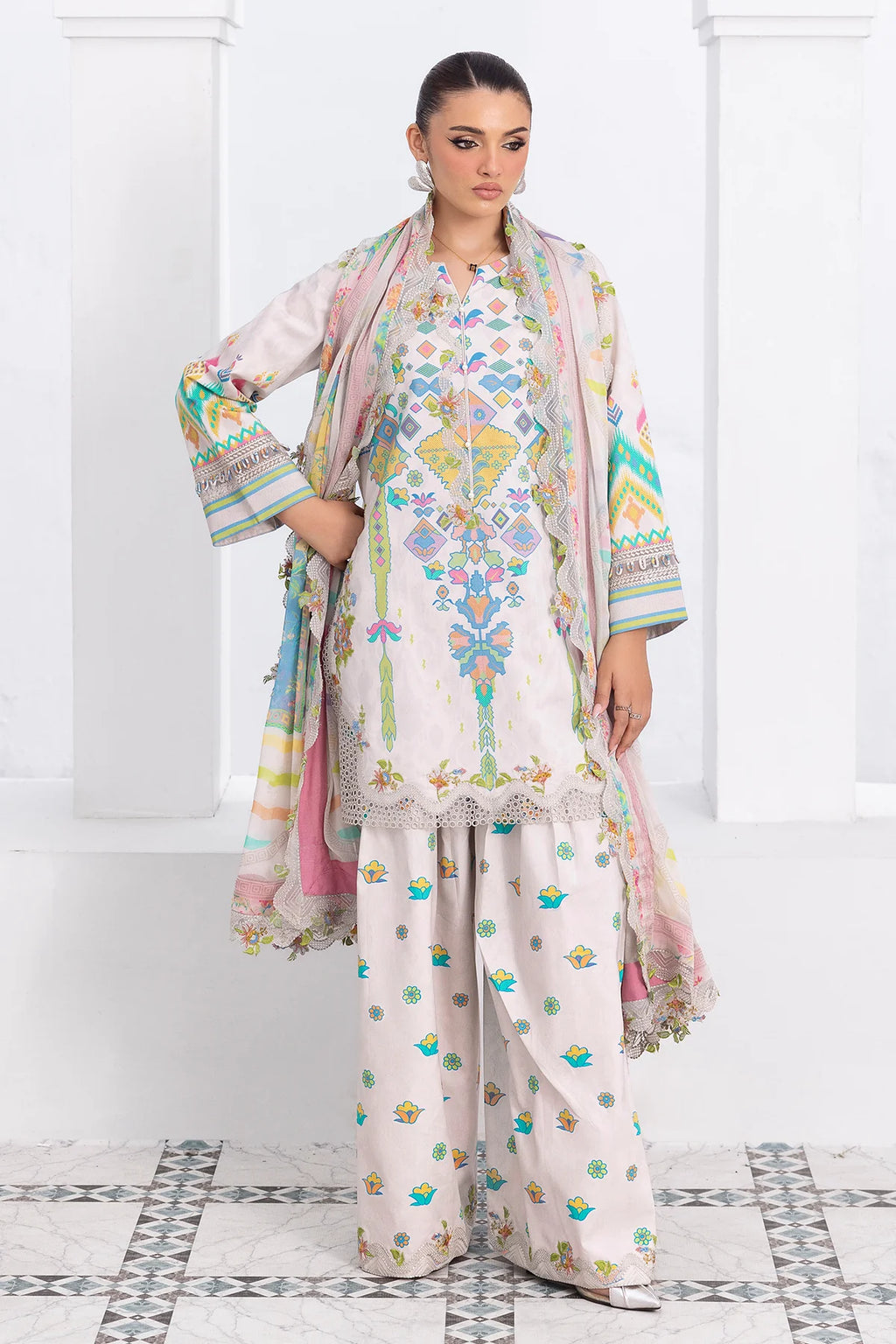 Woman wearing a traditional outfit with a floral design in a white room.