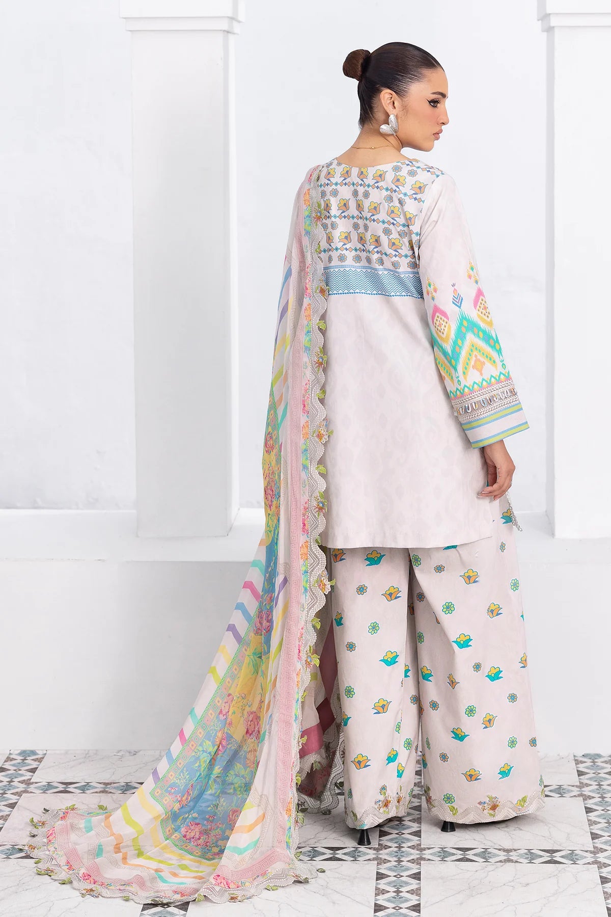 Woman wearing a traditional outfit with a colorful dupatta against a white background