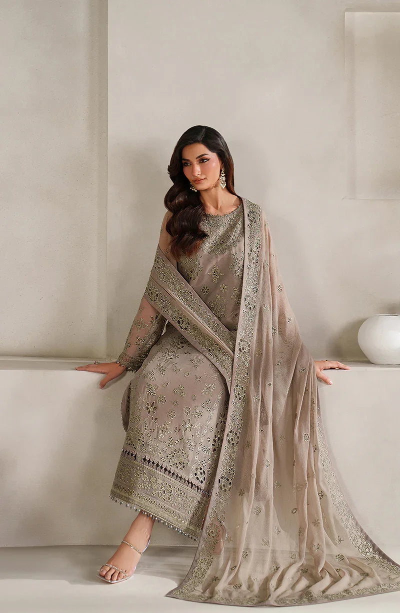 Woman in a traditional outfit with a beige and brown patterned dress and dupatta against a neutral background.