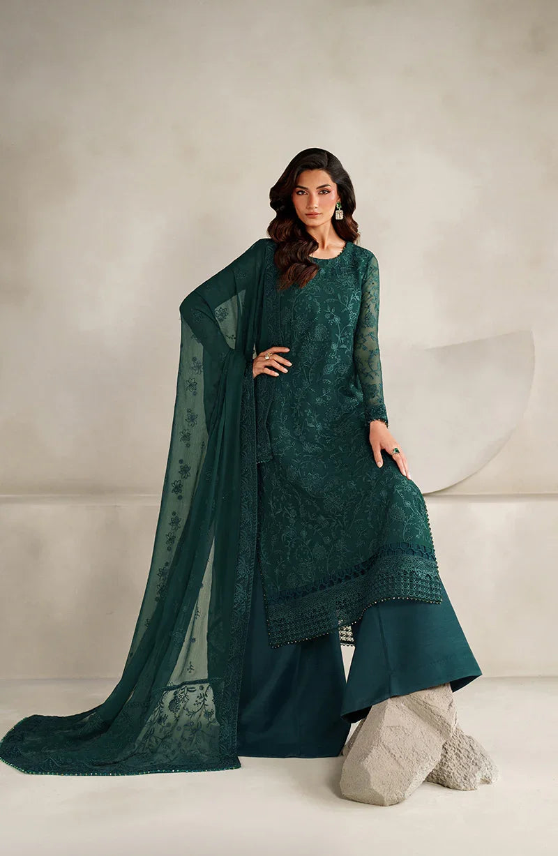 Woman wearing a teal traditional outfit with a matching dupatta on a neutral background